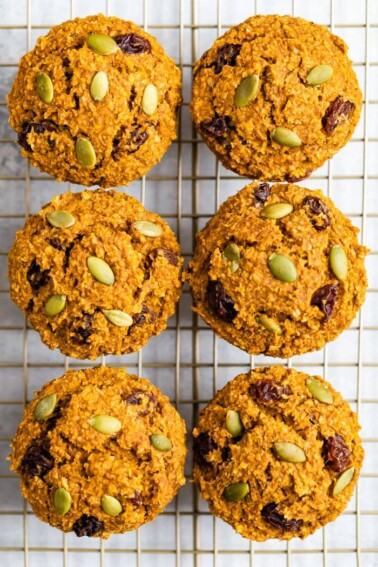 Six pumpkin bran muffins on a cooling rack, view from above the muffins.