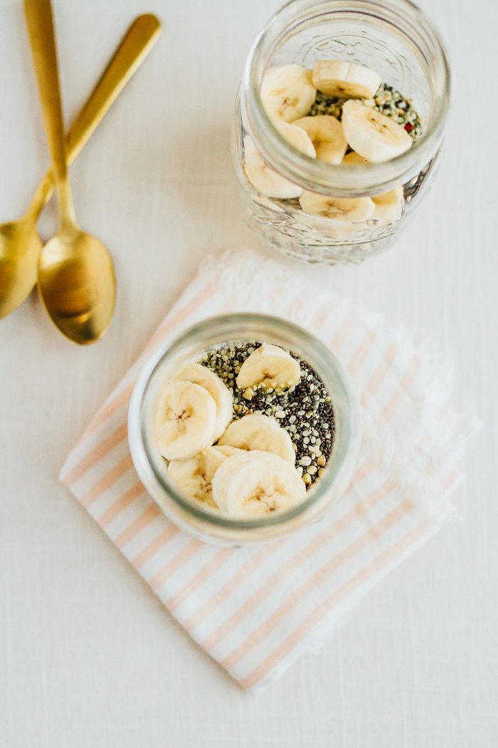 Cereal lovers rejoice! This healthy superfood cereal is loaded with nutrient-dense foods, plus it's gluten free, has no added sugars and packs a nice punch of omega-3s and protein. Put the cereal in a mason jar for easy transport when you need a quick on-the-go breakfast! Banana slices and chia seeds in two glass mason jars.