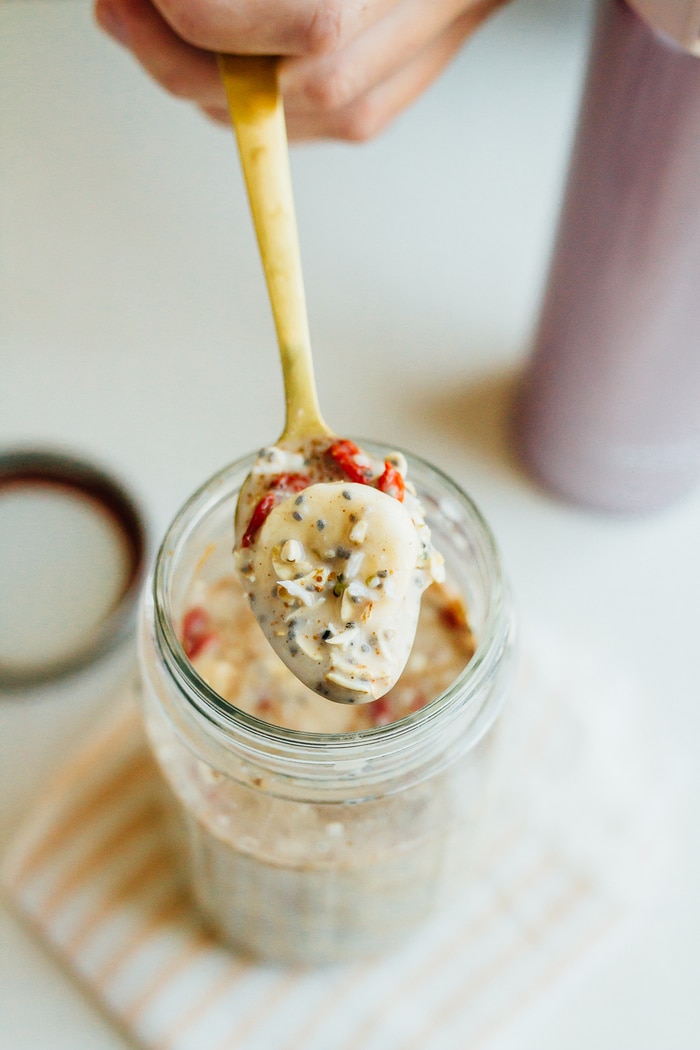 Cereal lovers rejoice! This healthy superfood cereal is loaded with nutrient-dense foods, plus it's gluten free, has no added sugars and packs a nice punch of omega-3s and protein. Put the cereal in a mason jar for easy transport when you need a quick on-the-go breakfast! A hand holding a gold spoon scooping superfood cereal out of a glass jar.