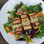 Lemon basil tofu served over a bed of mixed greens.