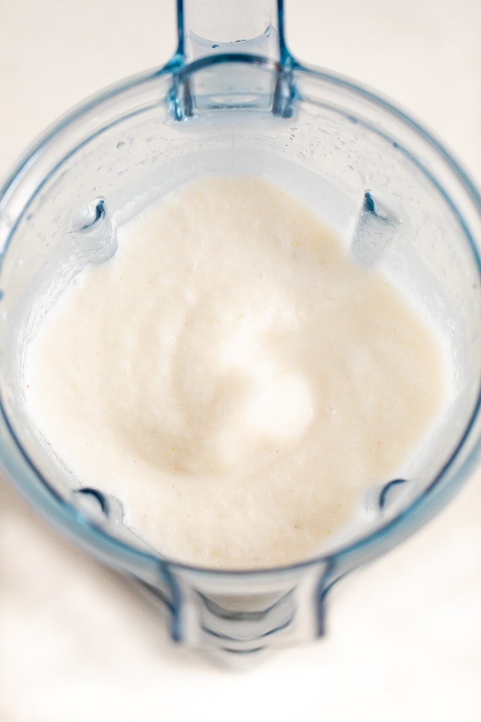 Overhead photo of a skinny coconut daiquiri in a blender.