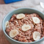 Banana almond teff porridge served in a light blue bowl.