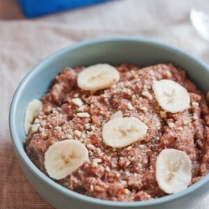 Banana almond teff porridge served in a light blue bowl.