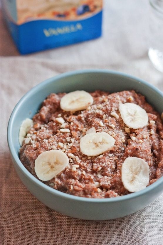 Banana almond teff porridge served in a light blue bowl.