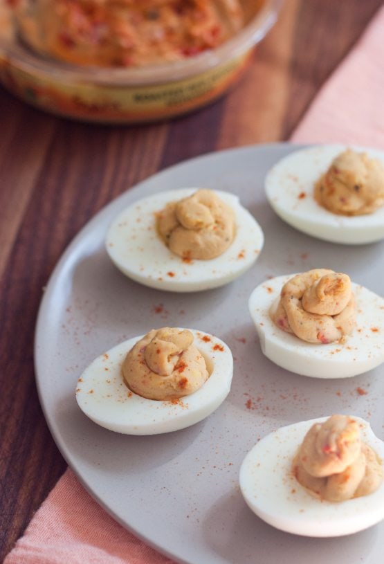 2 Ingredient Hummus Deviled Eggs Hummus deviled eggs served on a white plate.