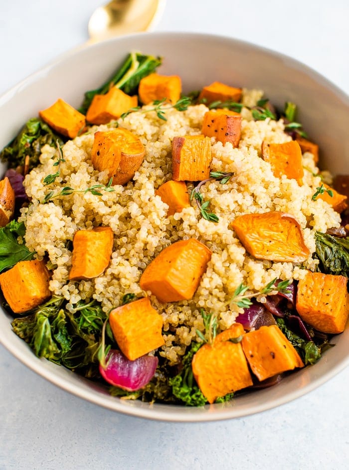 Kale salad with quinoa and roasted sweet potatoes on top.