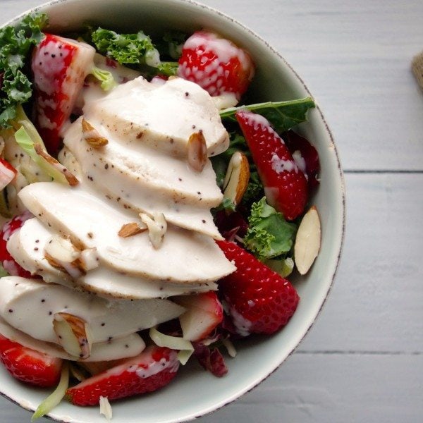 Strawberry Kale Slaw Chicken Salad with Poppyseed Dressing by Nutritionist in the Kitch Strawberry Kale Slaw Chicken Salad with Poppyseed Dressing in white bowl on white wood table