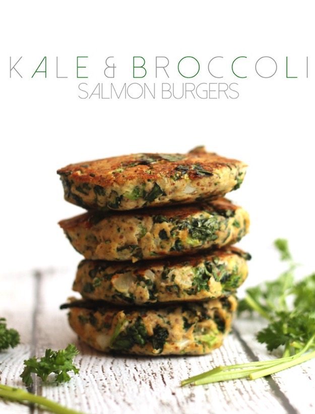 Kale and Broccoli Salmon Burgers by Hummusapien Kale and Broccoli Salmon Burgers stacked on a white table.