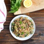 Mushroom kale quinoa risotto served on a white plate.
