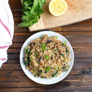 Mushroom kale quinoa risotto served on a white plate.