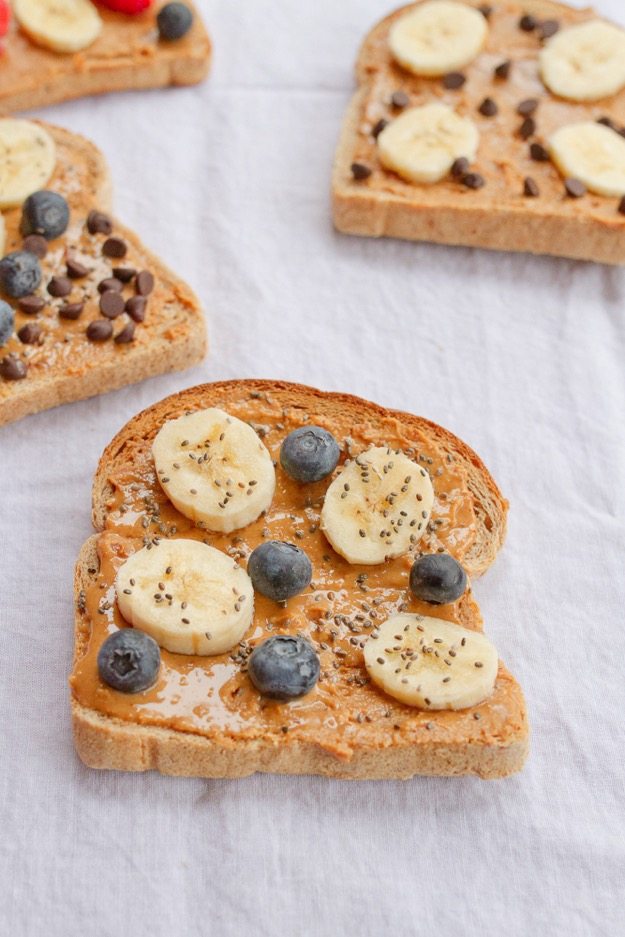 Banana Blueberry Chia Seed Peanut Butter Toast Peanut butter breakfast toast topped with fresh banana slices and fresh blueberries.