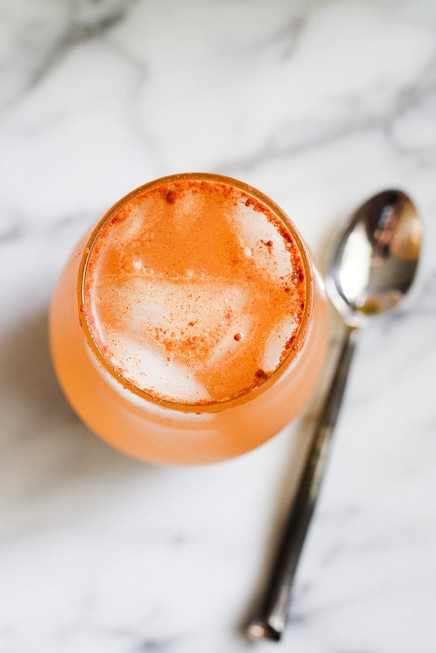 Detox gently with this Apple Pie Apple Cider Vinegar Drink! Apple Pie Vinegar Drink on a marble countertop with a silver spoon sitting next to it.