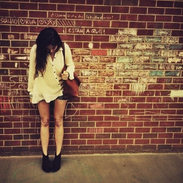 Dealing with Post Pill Amenorrhea Brittany standing in front of a brick wall looking down at her shoes.