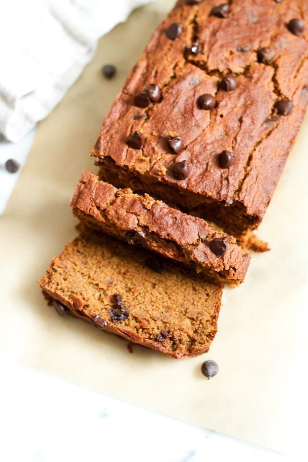 Spiced with cinnamon, nutmeg, ginger and allspice this moist and tender chocolate chip pumpkin bread is everything a pumpkin quick bread should be but a tad healthier, gluten-free and vegan. Sliced loaf of quinoa flour pumpkin bread on a piece of parchment paper.