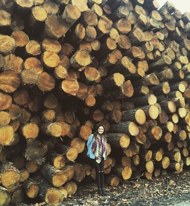 Post Pill Amenorrhea Update Brittany standing in front of tree logs.