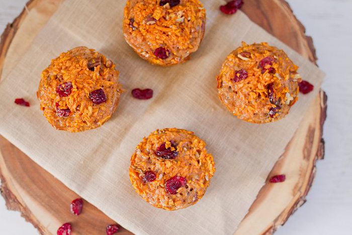 Spiralized cranberry pecan sweet potato muffins made with riced sweet potato noodles. They’re moist, filling and delicious served warm straight from the oven or at room temperature. Overhead photo of four muffins served on a wooden charger.