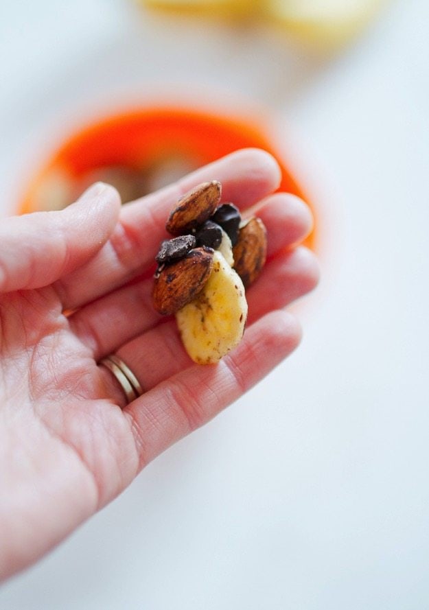 PIN THIS --> Chunky Monkey Trail Mix Hand holding trail mix with banana chips, chocolate and almonds.