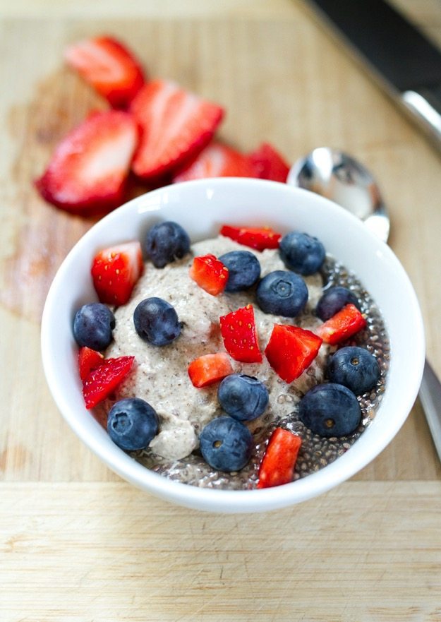 Eating Clean Creamy Breakfast Chia Pudding #dairyfree #glutenfree #vegan A bowl of creamy cashew chia pudding topped with blueberries and chunks of strawberry.