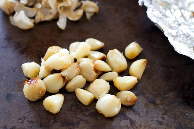 Make this delicious roasted garlic for healthy cooking! Roasted garlic that's been peeled on a baking pan.
