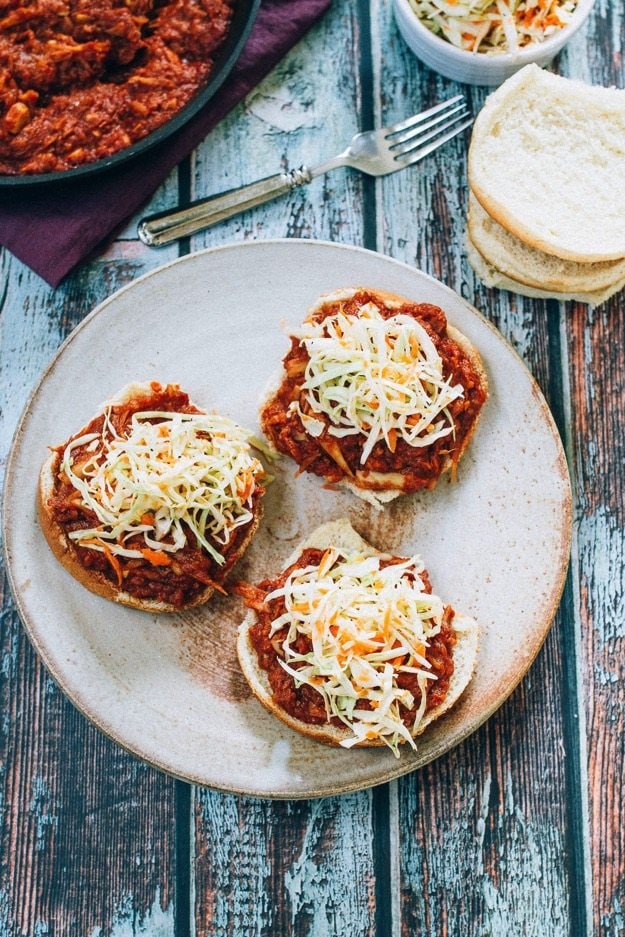 The BEST vegan BBQ sandwiches made with shredded hearts of palm, homemade BBQ sauce and a crunchy apple cider vinegar coleslaw. Three open-faced buns topped with shredded hearts of palm tossed in BBQ sauce and topped with coleslaw.