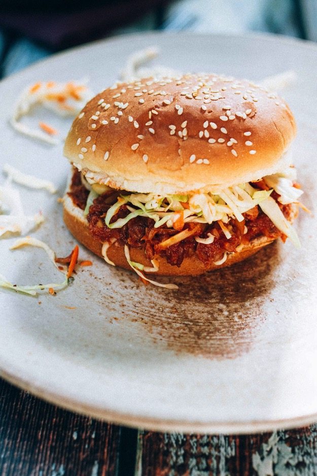 The BEST vegan BBQ sandwich made with shredded hearts of palm, homemade BBQ sauce and a crunchy apple cider vinegar coleslaw. Hearts of Palm BBQ sandwiches served on a sesame bun topped with coleslaw.