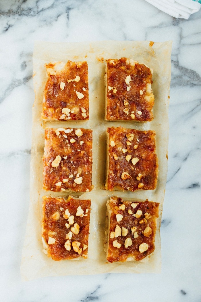 Pin this image to save a healthy banana ice cream bar recipe! Chocolate Date Caramel Banana Ice Cream Bars sliced on parchment paper.