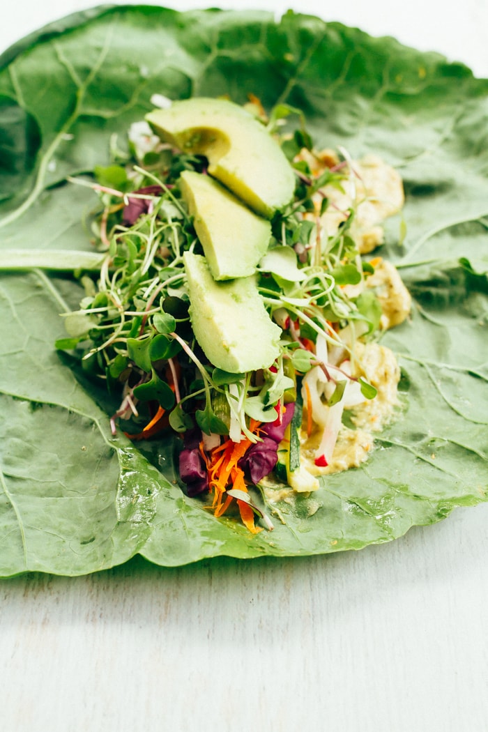 Pin this image to save this delish veggie packed hummus collard wraps recipe for later! Collard green wrap with hummus and veggies lined up across the top.