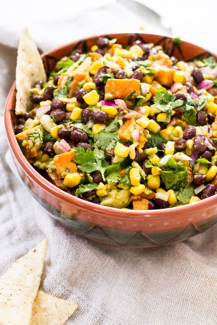 This delicious sweet potato black bean dip is loaded with flavor and perfect served with tortilla chips, as a side or as a topping for salads and tacos. #glutenfree #vegan Southwest sweet potato black bean dip topped with fresh cilantro.