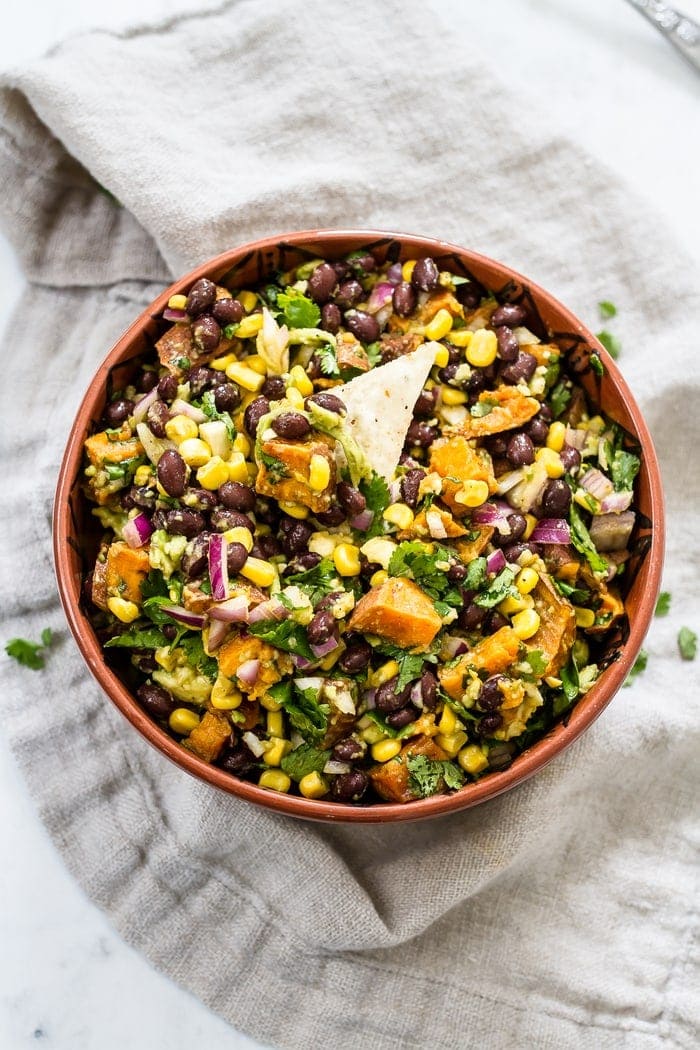 This delicious sweet potato black bean dip is loaded with flavor and perfect served with tortilla chips, as a side or as a topping for salads and tacos. #glutenfree #vegan Sweet potato black bean dip served with tortilla chips in a bowl.