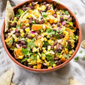Southwest sweet potato black bean dip served in a mixing bowl with tortilla chips.