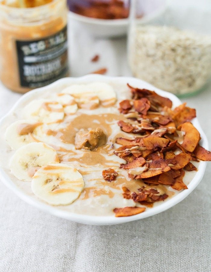 Overnight oats fit for the King with a combo of nutty peanut butter, fresh banana slices and crispy coconut bacon! A bowl of peanut butter banana and bacon overnight oats.