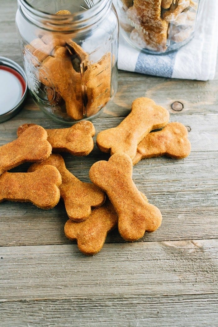 Overhead photo of homemade peanut butter and pumpkin dog treats on a wood surface.