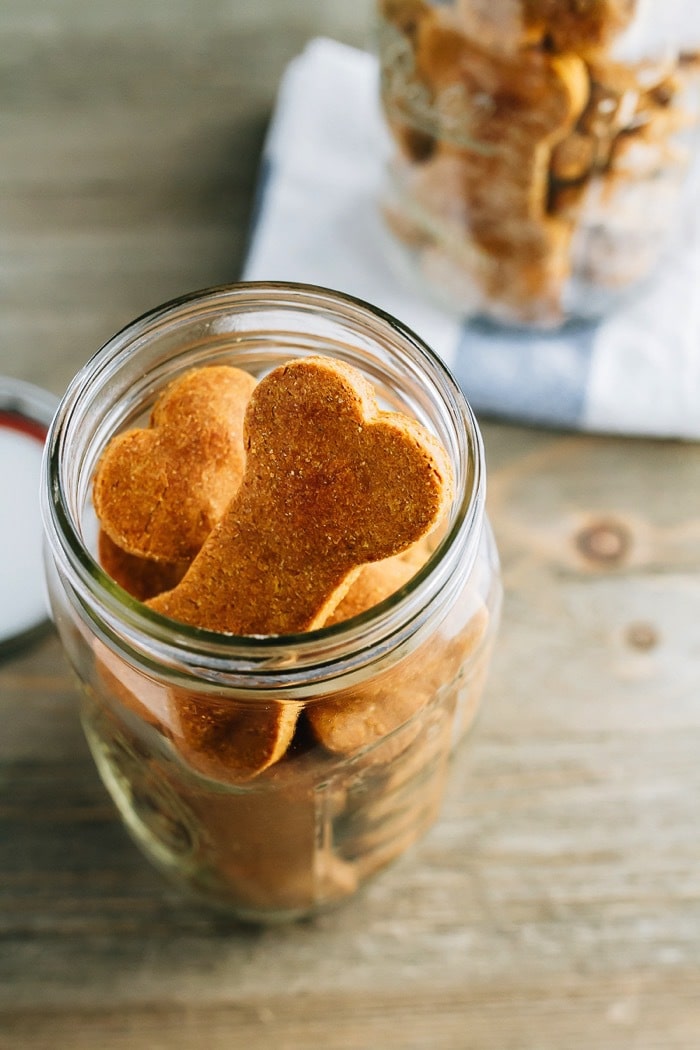 Overhead photo of homemade peanut butter and pumpkin dog treats in a clear mason jar.
