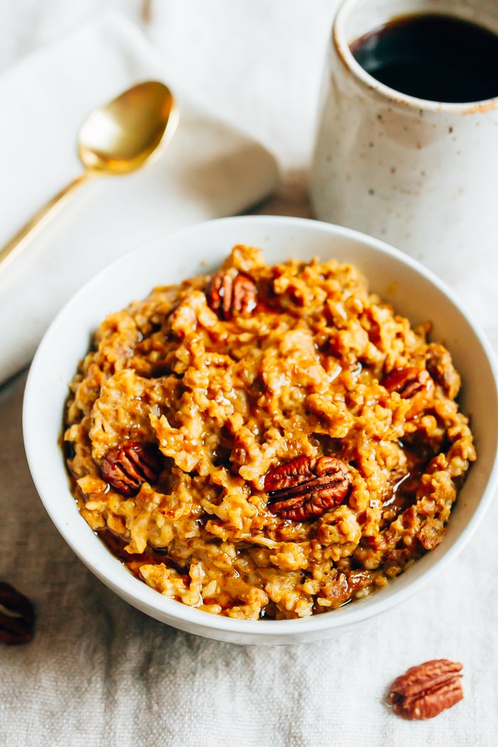 HEALTHY Slow Cooker Pumpkin Pie Oatmeal recipe! Slow Cooker Pumpkin Pie Oatmeal in a white bowl with pecans.