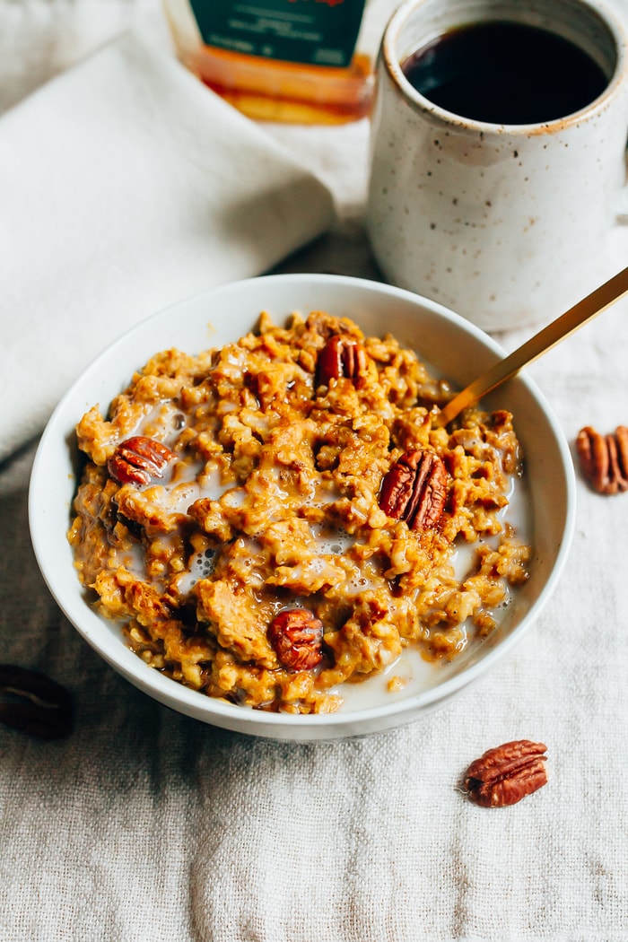 Pin this image to save this delish Slow Cooker Pumpkin Pie Oatmeal recipe for later! Slow Cooker Pumpkin Pie Oatmeal in a shallow bowl topped with pecans.