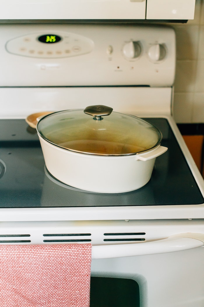 A slow simmered root vegetable tagine with apricots and rosemary! Serve this vegetarian dish as a side or over rice or quinoa for a complete meal. White dutch oven on a stove top.