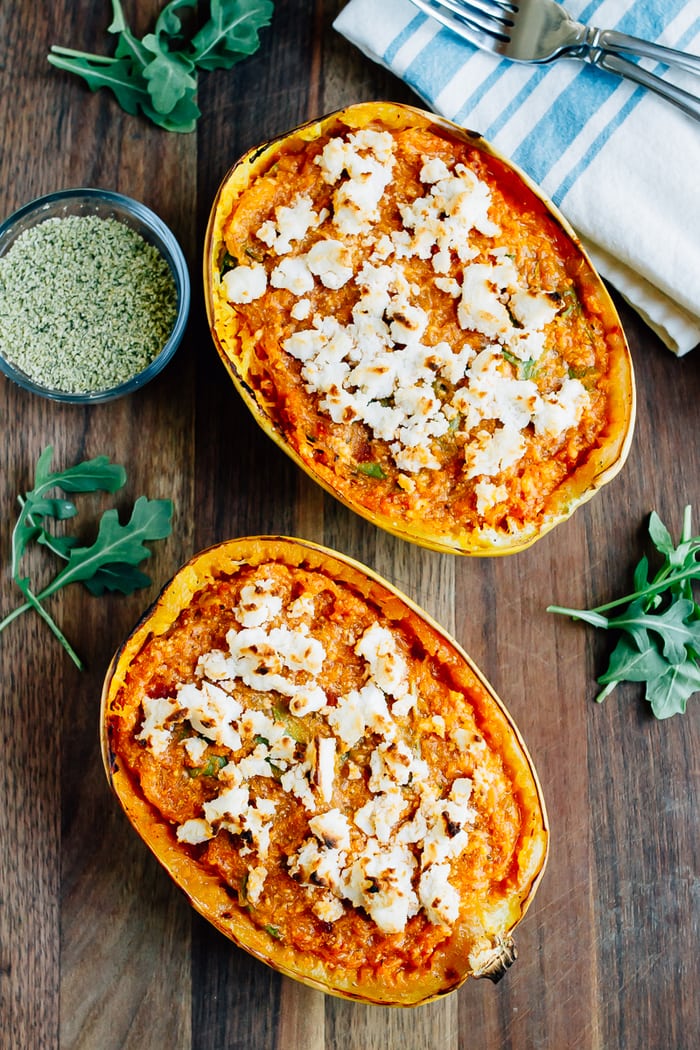 Turn spaghetti squash into a meatless meal with this recipe for stuffed SPAGHETTI SQUASH LASAGNA BOWLS. Made with vegan ricotta and hemp parmesan. Two spaghetti squash lasagna bowls topped with vegan cheese.