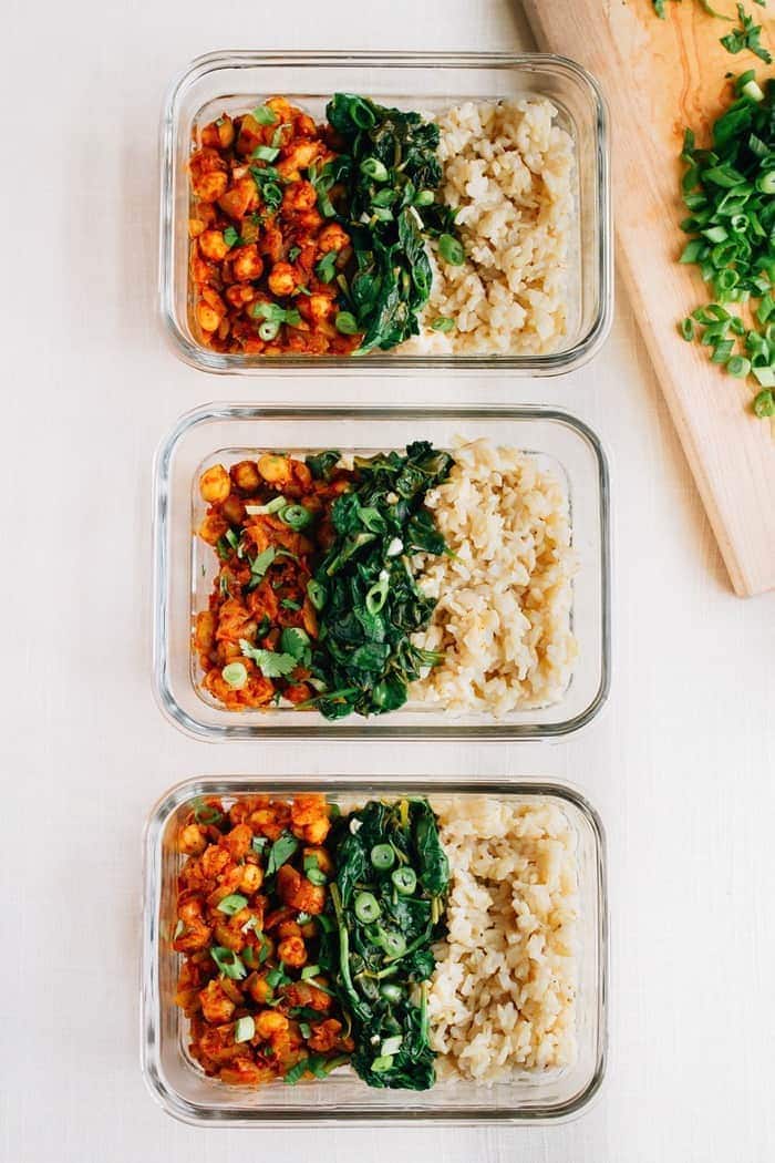 Curried Chickpea Meal Prep Bowls -- the BEST vegan meal prep recipe Three curried chickpea bowls served in glass tupperware containers alongside brown rice and spinach.