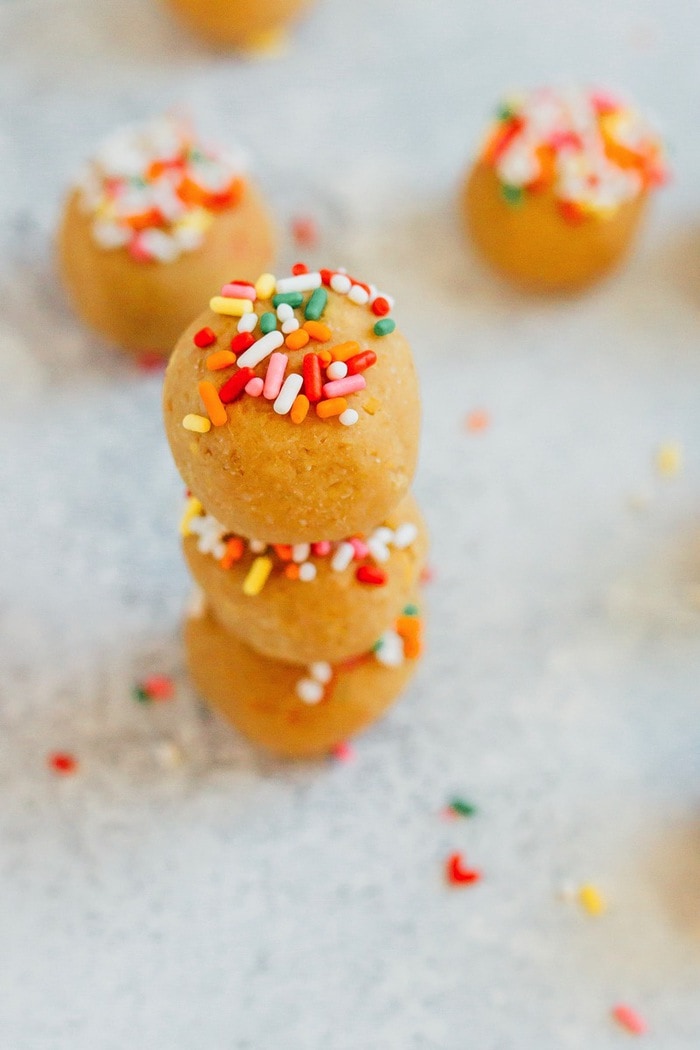 Have your cake and eat it too! These Vanilla Bake balls are moist, fluffy and taste like cake, but they're made with healthy ingredients like chickpeas, vegan protein powder and cashew butter. Vegan + gluten-free. Three vanilla cake balls stacked on top of each other.