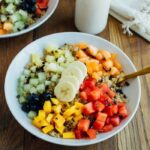 A quinoa breakfast bowl topped with a variety of fresh fruit.