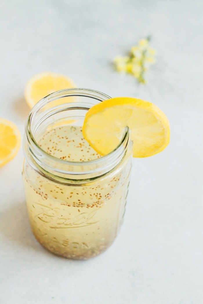 Lemon Chia Fresca in a clear mason jar with a slice of lemon.