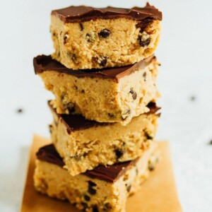 Four cookie dough bars stacked on each other all with a chocolate coating that tops them off.