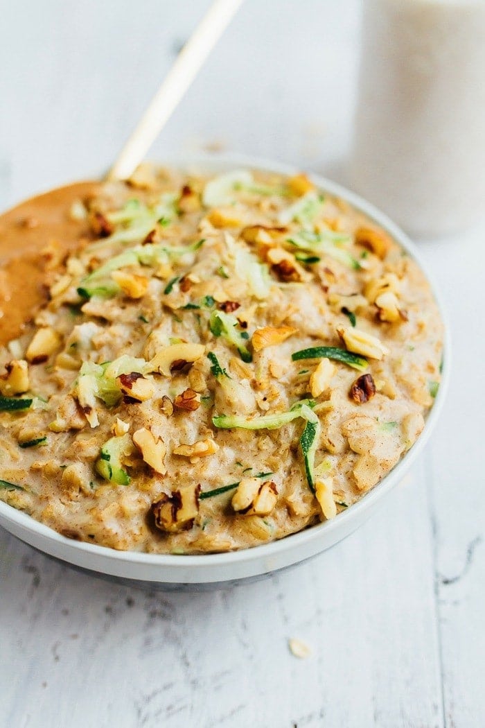 Add veggies and volume to your morning bowl of oats with this ZUCCHINI BREAD OATMEAL recipe. Bowl of zucchini bread oatmeal topped with walnuts and almond butter.