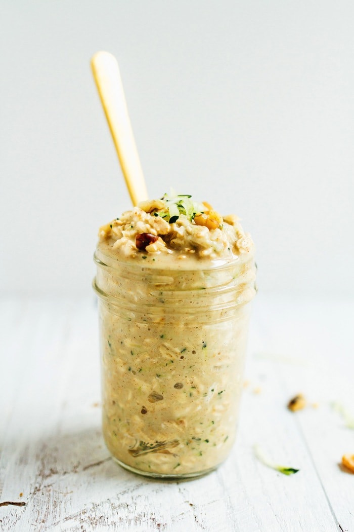 Zucchini bread overnight oats make for an easy and healthy portable breakfast. Made with oats, protein powder, grated zucchini and walnuts, these overnight oats are vegan and gluten-free. Zucchini bread overnight oats served in a glass mason jar with a metal spoon.