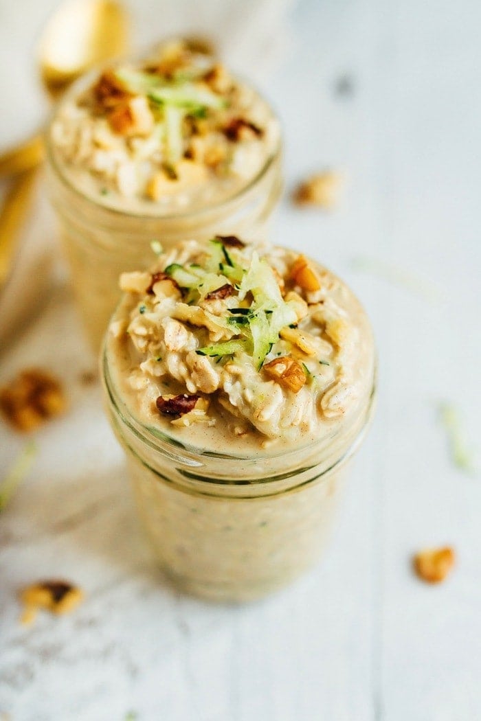 ZUCCHINI BREAD OVERNIGHT OATS // Vegan + Gluten-Free Zucchini bread overnight oats in small mason jars with walnuts and grated zucchini on top.