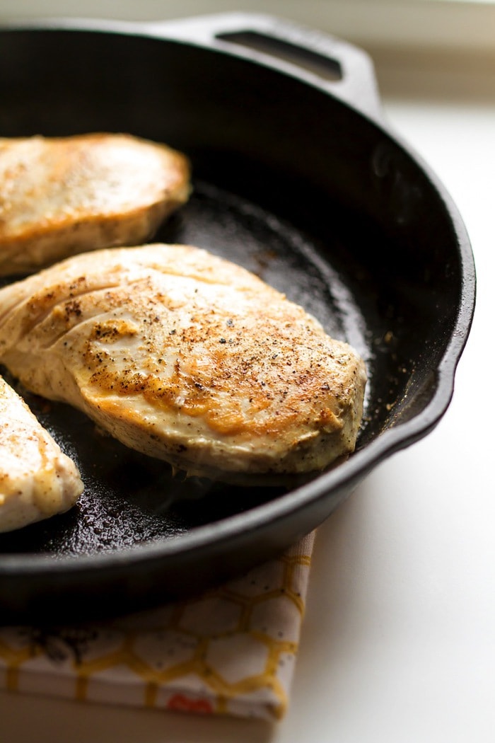 Maple turmeric chicken lightly seasoned in the cast iron skillet.