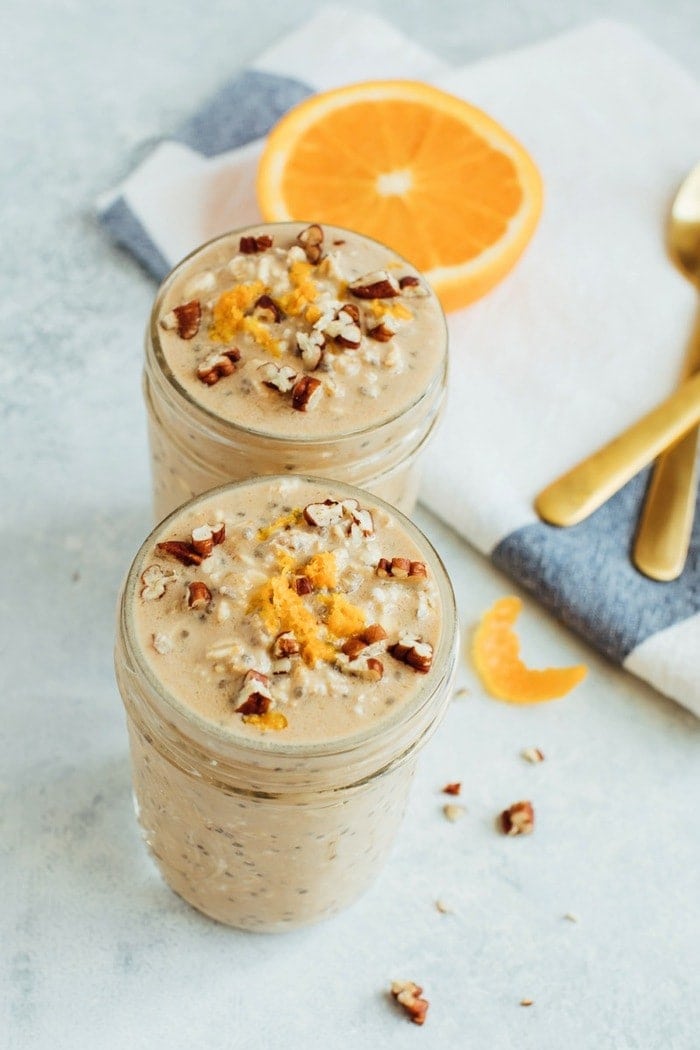 Orange Vanilla Overnight Oats // Vegan + Gluten-Free Two glass jars of orange vanilla overnight oats served with orange zest and crushed pecans.