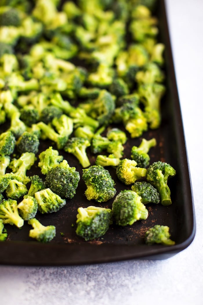 The best way to cook frozen broccoli! Pin this healthy cooking hack for later! Frozen broccoli on baking sheet.