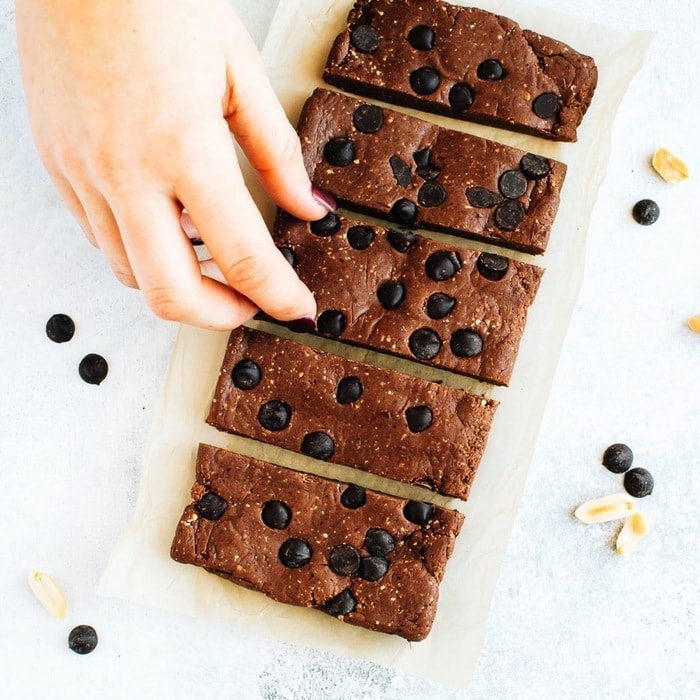 Pin this recipe for Homemade Peanut Butter Chocolate Protein Bars! Hand Reaching in for the Peanut Butter Chocolate Protein Bars
