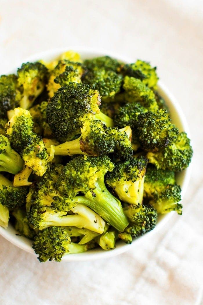 Yes, you CAN roast frozen broccoli — straight from the bag, no defrosting necessary. Trust me, this healthy cooking hack will save you so much time and money! #cookinghack #healthyeating #broccoli Roasted frozen broccoli in a bowl